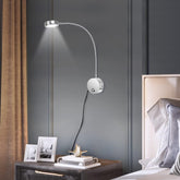 Modern floor lamp with adjustable arm in a bedroom setting.